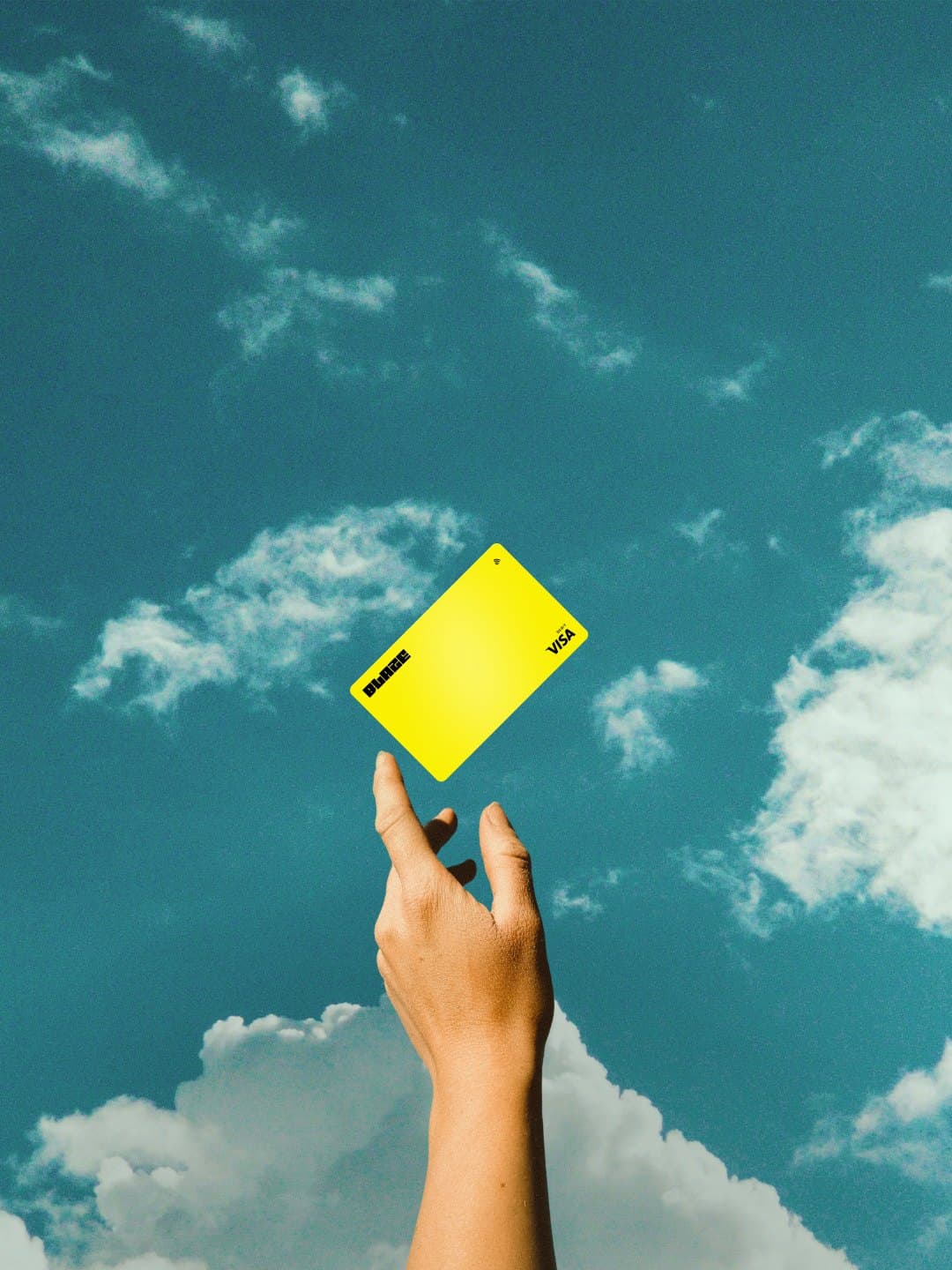 A hand reaching up to a yellow Blaze Card against the sky
