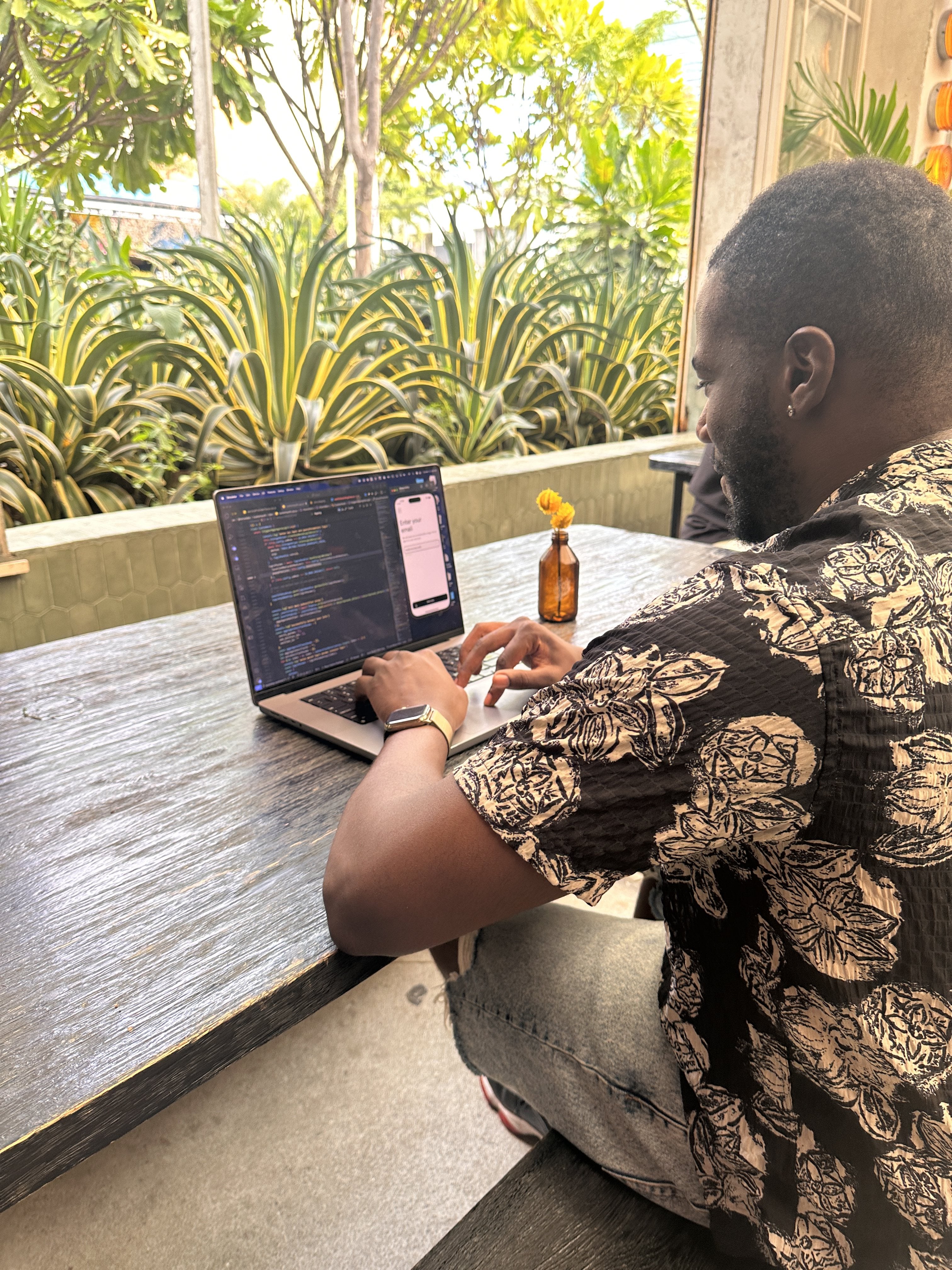 Luc writing code at a café table